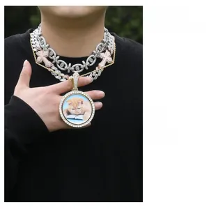 Close-up of layered hip hop Cuban chains with a rotating photo pendant and cross charms