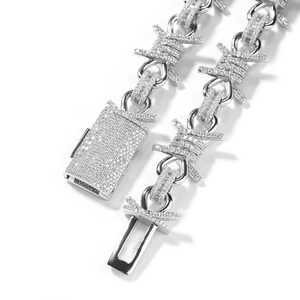 Macro shot of silver hip-hop barbed wire necklace with paved diamonds and rectangle clasp