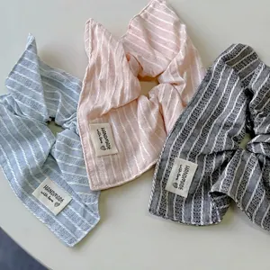 Trois chouchous rayés en tissu bleu rose et gris avec des étiquettes faites main
