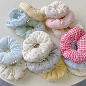 Floral and plaid fabric scrunchies in pastel colors on a clean white background