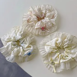 Three-piece set of floral fabric scrunchies with lace trim and handmade bow decorations