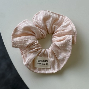 Vue détaillée de l'étiquette faite main sur un chouchou à rayures roses et blanches