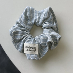 Détail d'un chouchou à rayures bleues avec une étiquette handmade with love cousue