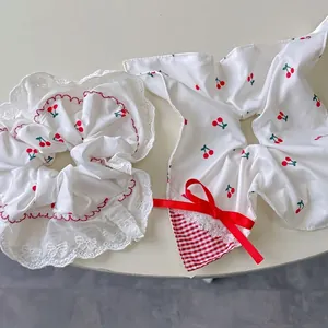Sweet cherry print hair scrunchie and lace bow ribbon hair tie set on beige background