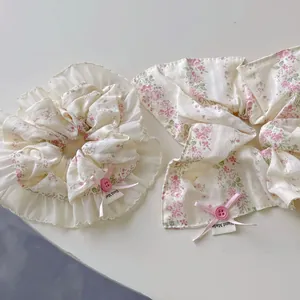 Detailed macro view of floral scrunchie with lace trim, pink ribbon bow and handmade label