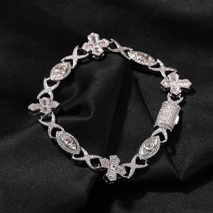 Macro shot of silver hip hop bracelet with iced-out cross and eye motifs on black silk