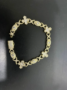 Detail of hip hop gold plated cross bracelet with evil eye links and CZ pavé clasp