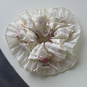 Detail of floral lace hair scrunchie with pink bow decoration and hand made label