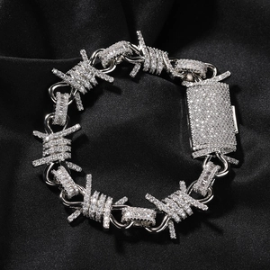 Macro view of hip hop barbed wire necklace with paved rhinestones on black silk