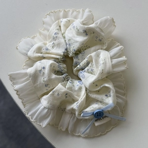 Detail of floral scrunchie with lace trim, blue bow, button and Hand Made label