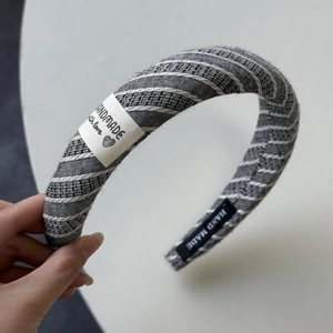 Détail d'un bandeau large à rayures grises avec étiquette en tissu fait main et texture