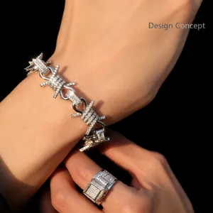 Close-up of hip hop barbed wire bracelet and square pavé ring with white stones