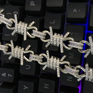 Macro shot of silver hip hop barbed wire necklace with iced-out cubic zirconia stones