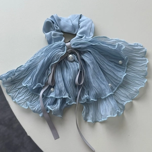 Détail du chouchou plissé bleu clair surdimensionné avec perle et rubans de soie élégants
