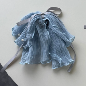 Détail de la pince à cheveux en mousseline plissée bleu clair avec nœud et perles