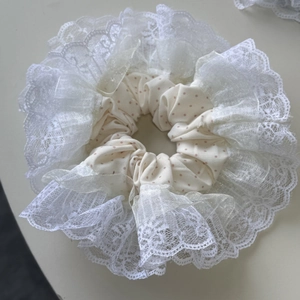 Vue détaillée du grand chouchou crème à pois avec bordures en dentelle et organza
