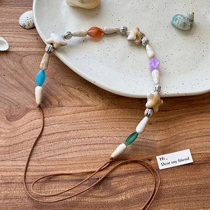 Bandeau bohème avec conques naturelles et perles d'étoiles colorées sur cordon de cire