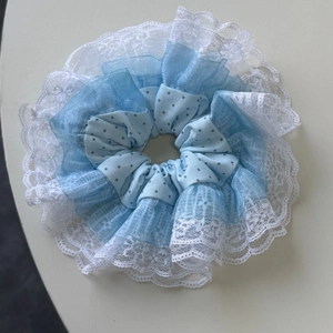 Gros plan sur chouchou français à pois bleus avec dentelle et tulle multicouche délicat