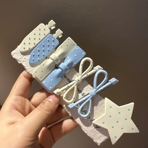Set of seven light blue and white polka dot bow hair clips for girls displayed on card