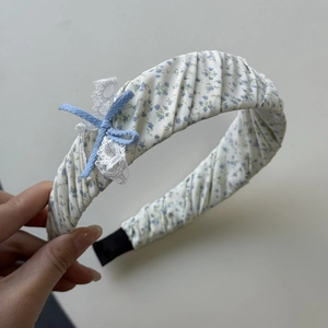 Detail van blauwe bloemen scrunchie met delicate kanten randen en een kleine strik