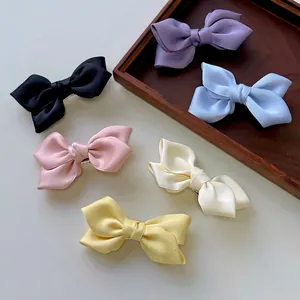 Set of six colorful satin ribbon bow hair clips in black, purple, blue, pink, and beige