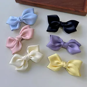 Elegant satin bow hair clips in six pastel colors on a minimalist background