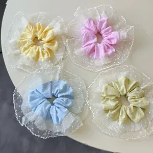 Lot de quatre chouchous en dentelle aux tons pastel jaune, rose, bleu et vert clair