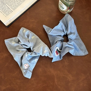 Blue denim style scrunchies set with rabbit charm and cherry embroidery on leather background