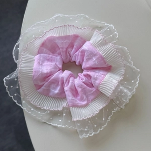Gros plan détaillé du chouchou en dentelle à trois couches avec carreaux roses
