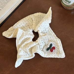 Detail of white lace scrunchie with heart cherry embroidery on a vintage background