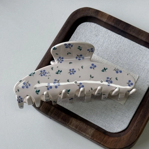 Dettaglio molletta per capelli crema con stampa bacche blu e accenti di strass lucidi
