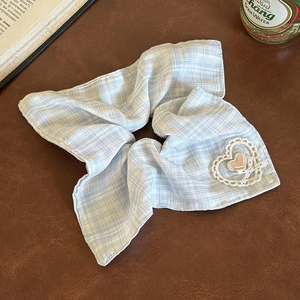 Detail of light blue plaid scrunchie with lace heart and pink embroidery hair accessory
