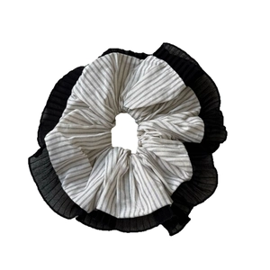 Elegant white checkered scrunchie with black pleated edges for a stylish hair accessory