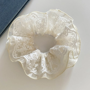 Elegant cream lace scrunchie with floral embroidery and mesh texture for hair styling