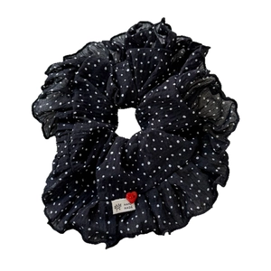 Chouchou à pois noir et blanc avec un détail de bouton en forme de cœur rouge