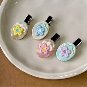 Set of four colorful floral acetate hair clips with marble texture on oval bases