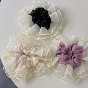 Three oversized ruffled lace scrunchies in black, cream, and lavender for ponytails
