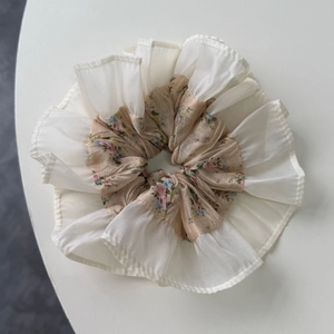 Détail d'un chouchou floral avec dentelle en mousseline blanche et motifs de fleurs