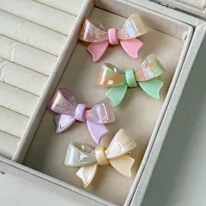 Pastel acetate bow hair clips in pink, green, purple, and cream with marble texture