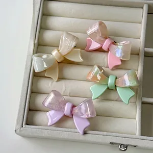 Pastel acetate bow hair clips in cream, pink, green, and purple with marble texture