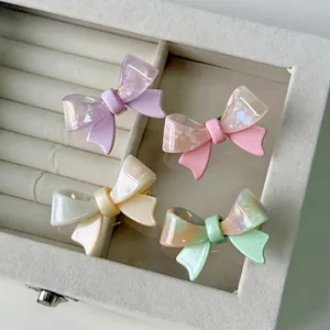 Set of four pastel bow hair clips in acetate with marble texture on velvet background