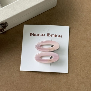 Barrettes à cheveux ovales roses en acétate avec pinces à bec sur carte