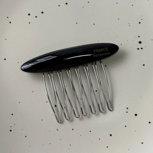 Detail of 10-tooth metal hair comb with black acetate top and FRANCE Handmade engraving