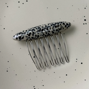 Detail view of Dalmation pattern hair comb with gold France handmade lettering and silver teeth