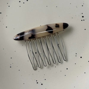 Detail of tortoise shell acetate hair comb with eight sturdy silver metal teeth