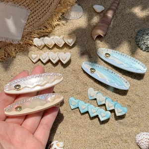 Ocean style acetate shell heart hair clips with golden accents for beach vacations