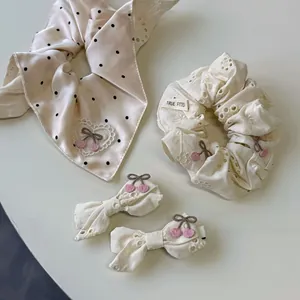 Détail d'un ensemble de chouchous en dentelle florale et de barrettes à nœuds roses