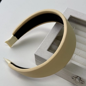 Detailed close-up of a wide thickened cream hairband with non-slip lining and ribbon ends