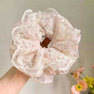 Elegant oversized lace scrunchie in light pink featuring floral patterns and soft mesh