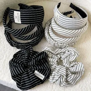 Detail shot of black and white striped fabric headbands and scrunchies with textile labels